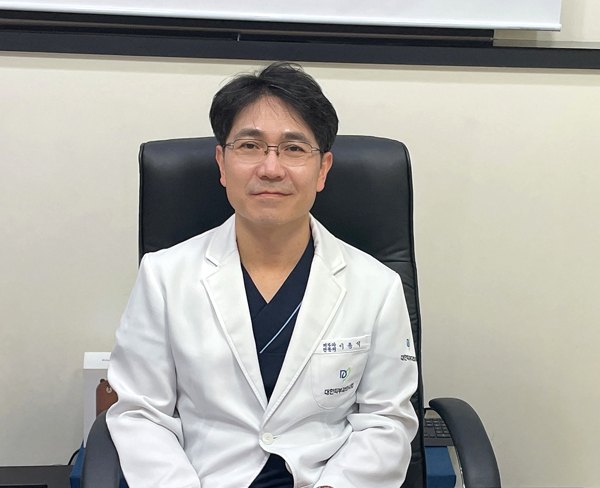 진료실 의자에 앉은 이용석 원장과 현미경