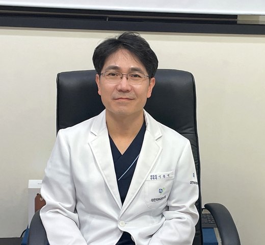 진료실 의자에 앉은 이용석 원장과 현미경